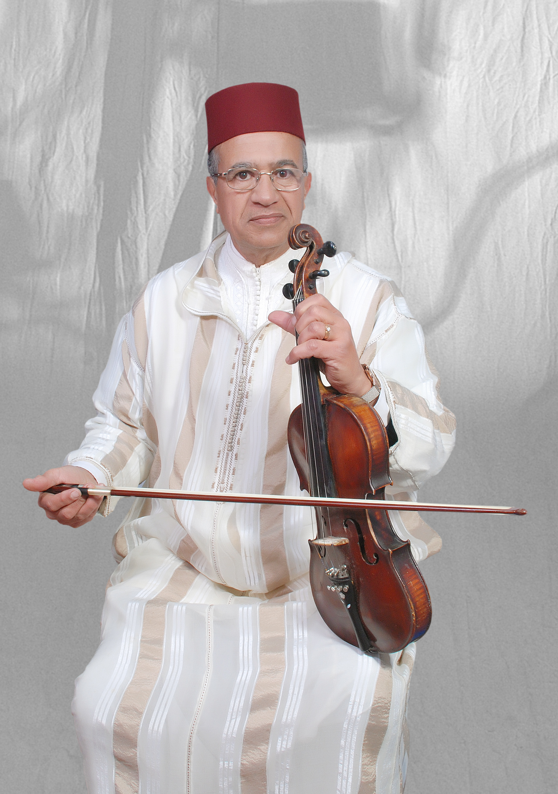 Portretfoto van Mohameh Aminn Akrami die een viool vastheeft.