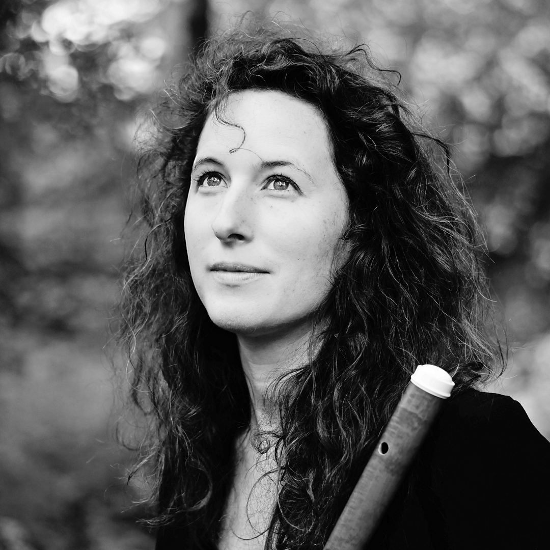 Adeline Salles is fluitiste bij Marmoucha Orchestra, gespecialiseerd in orkesten en kamermuziek. Adeline staat op deze zwart-witfoto met een dwarsfluit in haar handen.